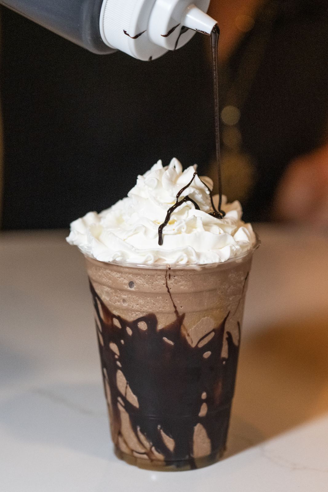 A mocha frappe with whipped cream and chocolate drizzle