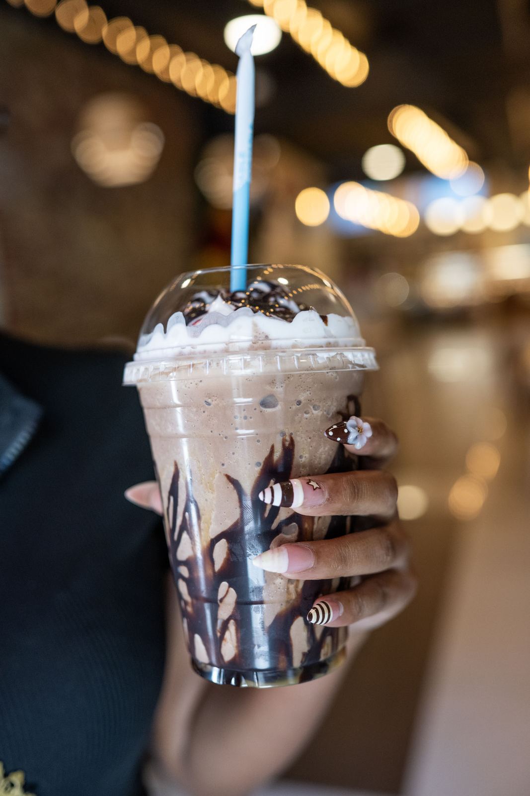 A cookies and cream frappe held up inside the cafe